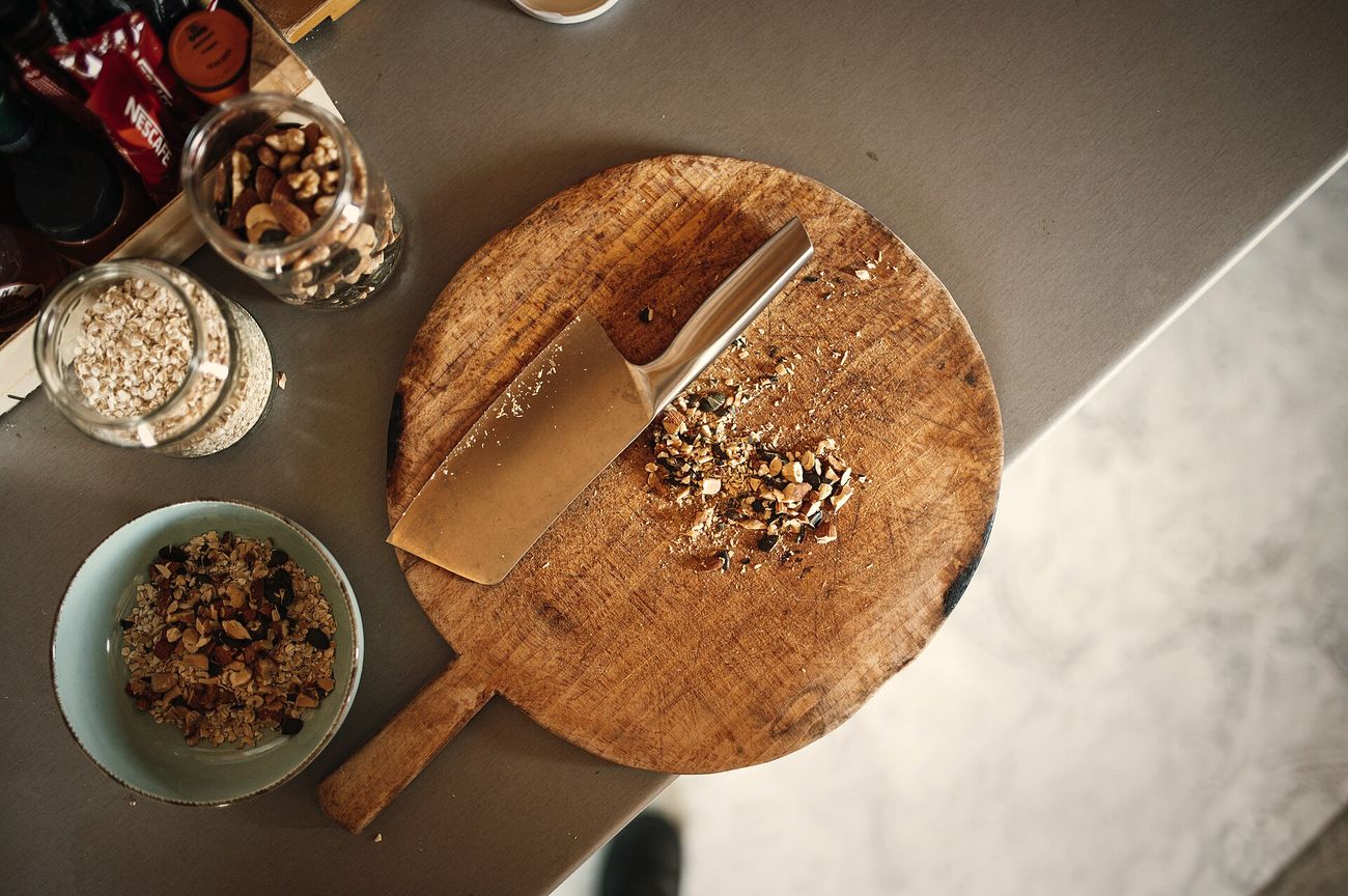A chef finely preparing herbs on a wooden board